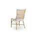 Natural rattan outdoor dining side chair viewed from the angled rear with black and white woven wicker back.