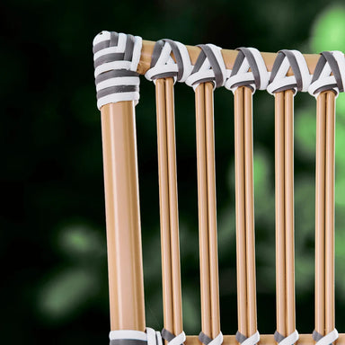 Close-up of the natural rattan outdoor dining side chair backrest with black and white woven wicker detailing.