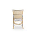 Natural rattan outdoor dining side chair viewed from the rear with black and white woven wicker back.