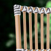 Close-up of the natural rattan outdoor bistro armchair backrest featuring black and white woven wicker.