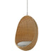 Natural rattan outdoor hanging egg chair with a gray cushion suspended by a metal chain.