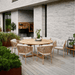 Boxhill's Ocean Outdoor Dining Armchair lifestyle image with teak round dining table at patio