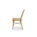 Natural rattan outdoor dining side chair viewed from the side with an open woven back and woven seat.