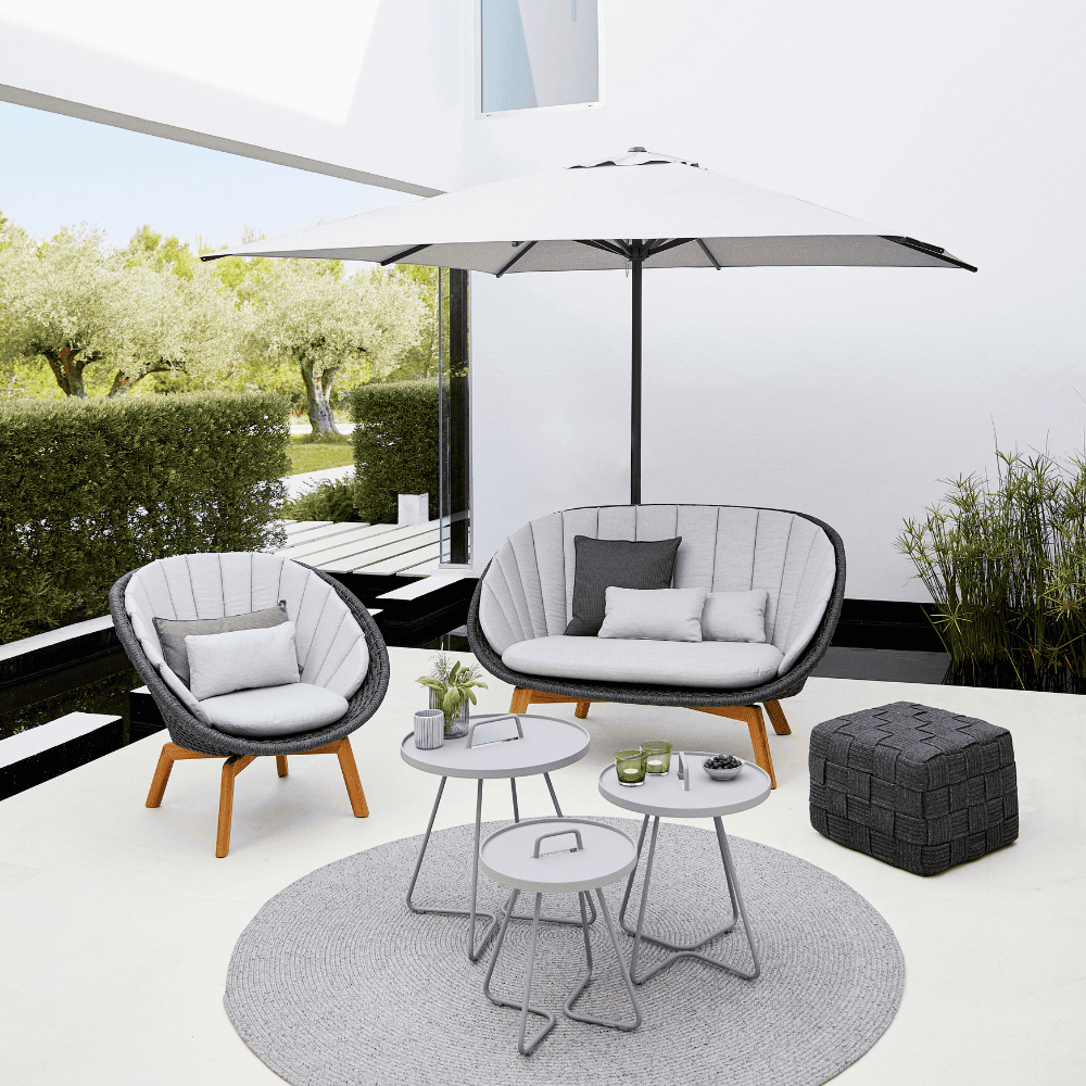  Boxhill's On-The-Move 3 light grey outdoor round side table with grey outdoor lounge chair and sofa and white parasol placed in patio