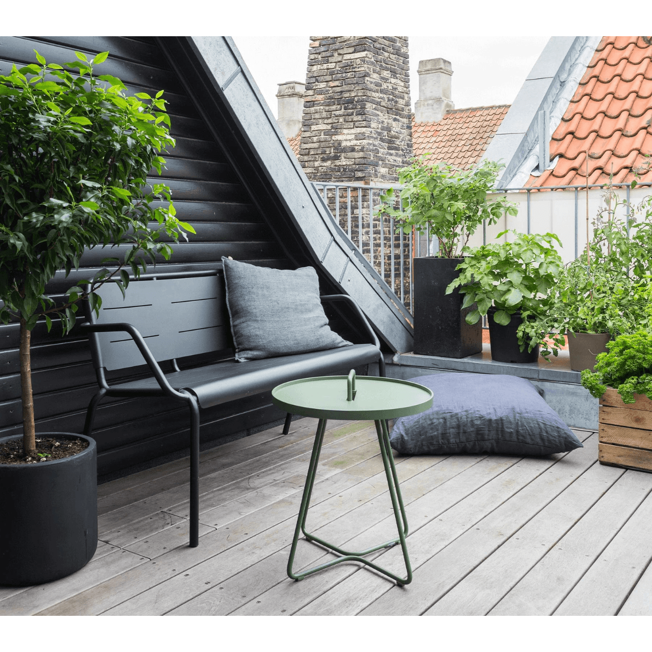Boxhill's On-The-Move olive green outdoor round side table along with plants and 2-seater black aluminum chair place on balcony