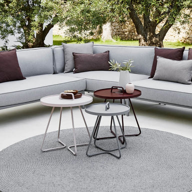 Outdoor patio with a sectional sofa, small outdoor side tables, and decorative items.