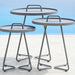 Set of three outdoor round aluminum side tables in light grey with handles on a light blue background