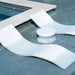 Modern white curved outdoor lounge chairs and a small round side table arranged by a swimming pool with clear water.