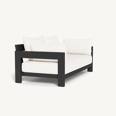 Side angle view of a black and white modern outdoor loveseat with plush cushions for luxury patio seating.