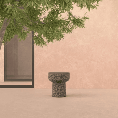 A concrete side table that has an abstract honeycomb texture reminiscing hammered metal.