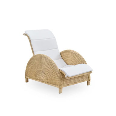 Natural rattan outdoor lounge chair with curved armrests and white seat and back cushions.