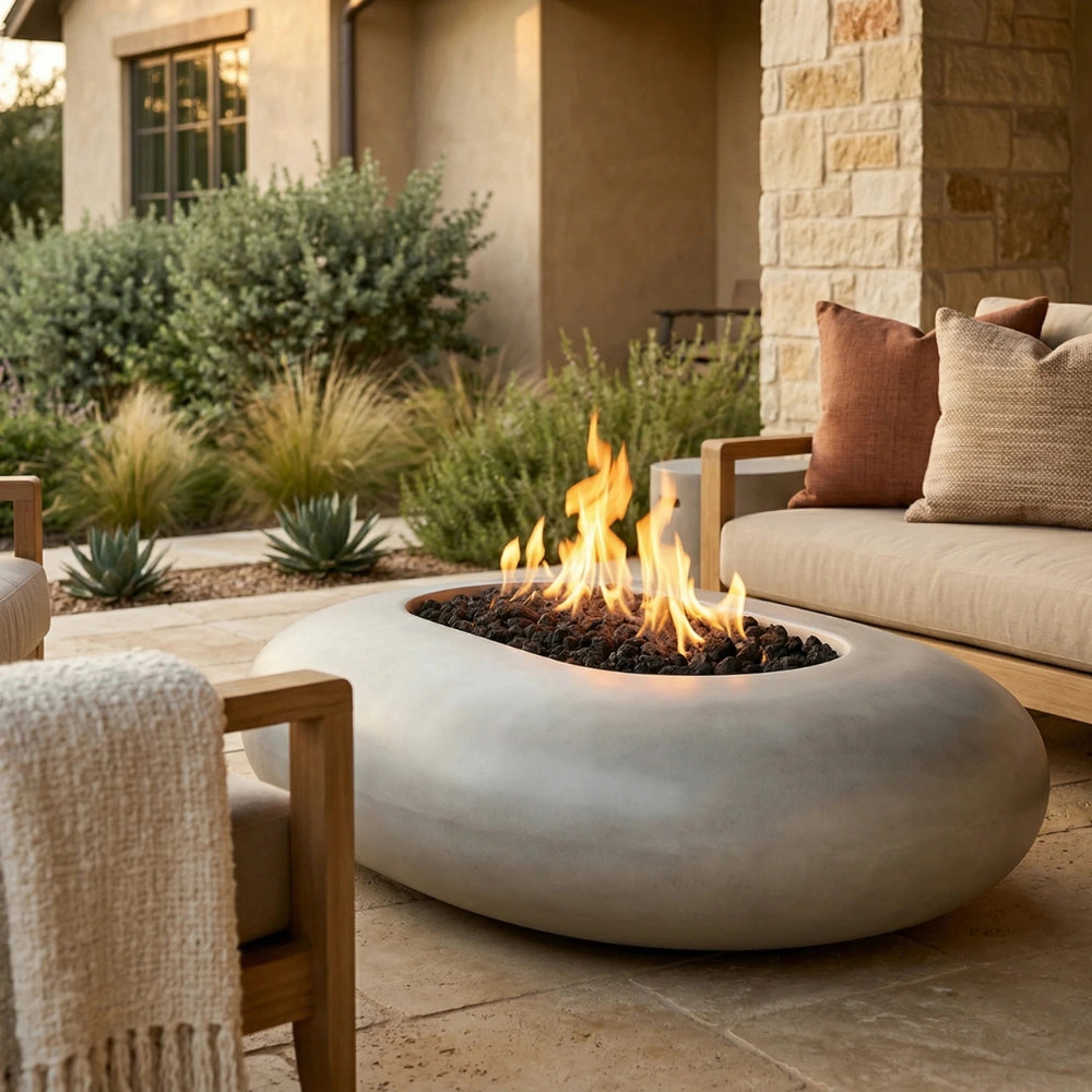 Outdoor patio with grey oval concrete fire pit, seating area, and garden.