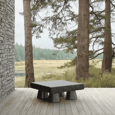 A concrete coffee table that has a smooth, polished table top and base with a carved edge detail.