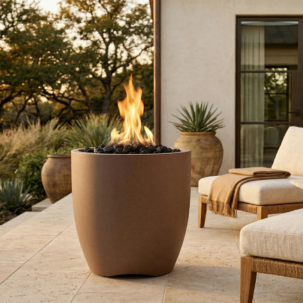 Outdoor patio with a tall cylinder-shaped outdoor concrete brown fire pit, chairs, and potted plants.