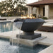 Outdoor round concrete fire pit with water feature next to a pool