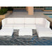 A white outdoor sectional sofa with matching ottomans placed in a swimming pool at a resort or patio setting.