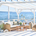 Natural rattan outdoor 3-seater sofa with white cushions beside a matching lounge chair.
