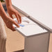 Person using a contactless payment device on a white surface