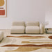 Rectangular rug in beige and brown hand-tufted polyester with abstract pattern, styled in living room