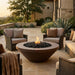 Outdoor patio with round concrete fire pit and comfortable seating area
