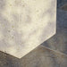 Close-up of white speckled concrete outdoor coffee table base on a gray tiled floor