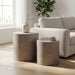 Modern living room with two gray cylindrical concrete outdoor side tables in different sizes beside a light gray sofa