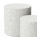 Close up of two cylindrical concrete outdoor side tables with speckled texture in different sizes on a white background