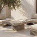 Patio seating with modern gray  concrete rectangular outdoor coffee table surrounded by gray cushioned chairs