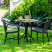 Black rattan outdoor dining armchair beside a round teak café table with a black pedestal base.