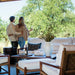 Couple standing by a patio with outdoor furniture and greenery