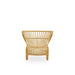 Natural rattan outdoor lounge chair viewed from the rear with a sculptural woven frame.
