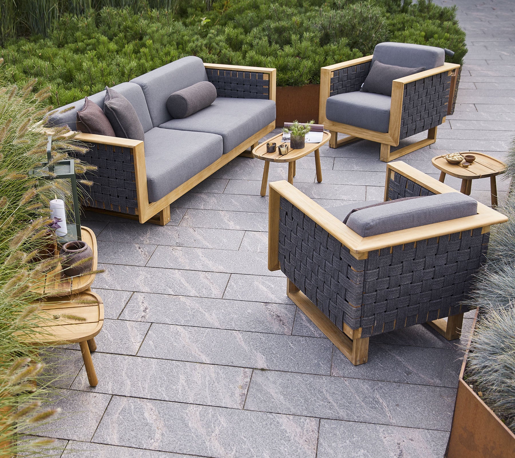 Boxhill's Angle 3-Seater Teak Frame Sofa lifestyle image with Angle Teak Frame Lounge Chair at the garden