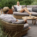 Boxhill's Basket 2-Seater Outdoor Sofa Natural lifestyle image with man and woman sitting down