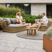 Boxhill's Basket 2-Seater Outdoor Sofa Natural lifestyle image at the garden with man and woman sitting down