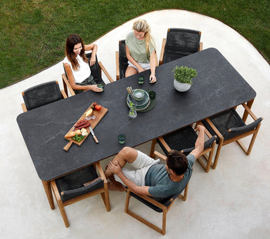Boxhill's Aspect Dining Table Fossil Black lifestyle image top view with 3 people sitting down
