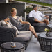 Boxhill's Basket 2-Seater Outdoor Sofa Graphite lifestyle image with 2 people sitting down