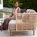Boxhill's Sense light brown 3-seater outdoor sofa placed in patio with a woman sitting on it