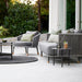 Boxhill's Moments 3-Seater Sofa lifestyle image with Moments Outdoor Lounge Chair and 2 round table at patio