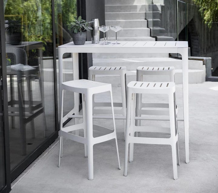 Boxhill's Cut Outdoor Aluminum Bar Table White lifestyle image with Cut High Outdoor Bar Chair at patio
