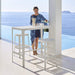 Boxhill's Cut High Outdoor Bar Chair White lifestyle image with Cut High Outdoor Bar Table and a woman standing beside the pool