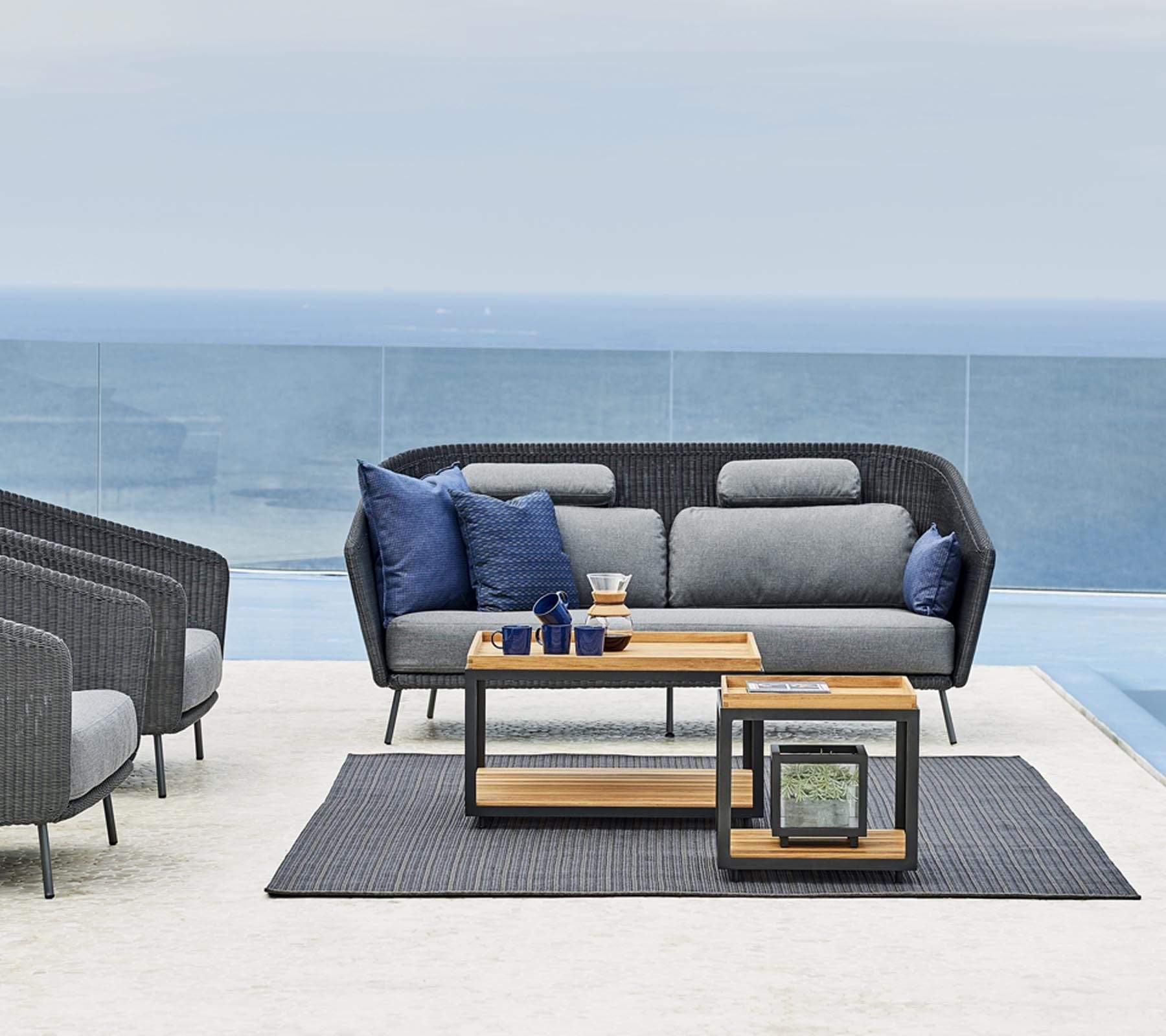 Boxhill's LEVEL Square Coffee Table Lava Grey with Teak Table Top lifestyle image with 2-seater sofa and 2 lounge chairs beside the pool 