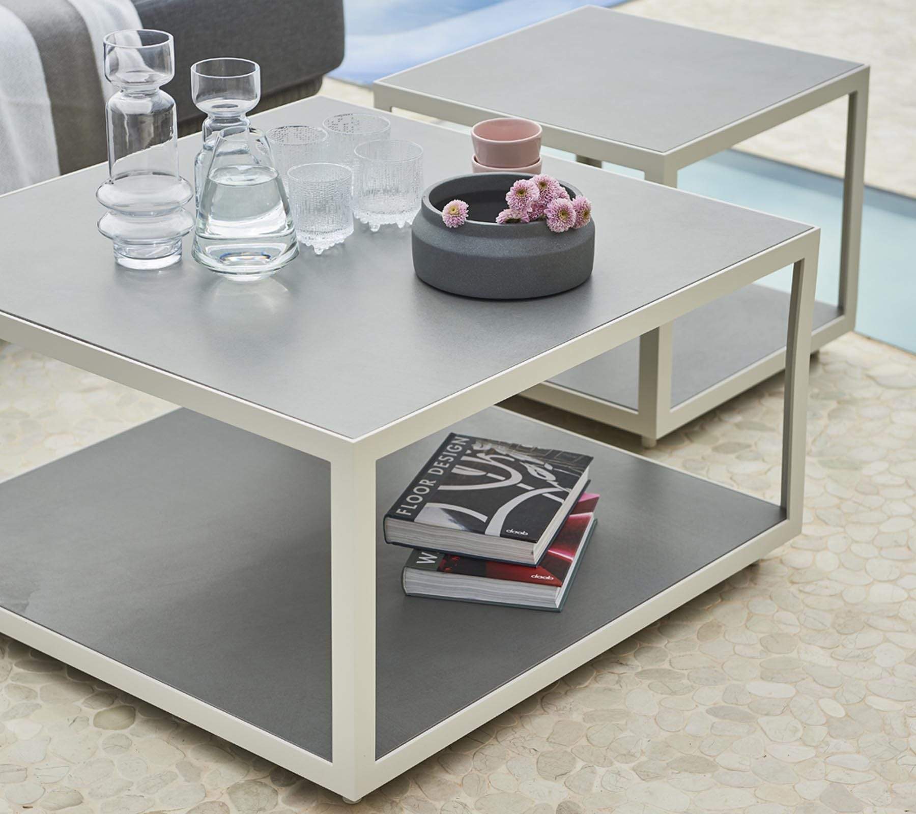 Boxhill's LEVEL Square Coffee Table White lifestyle image with glasses of water and water container on top, and 2 books under