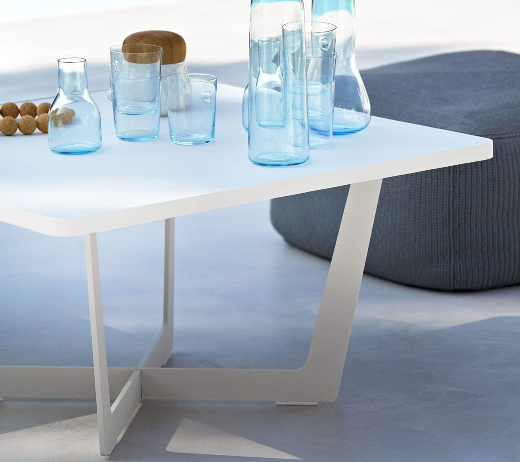 Boxhill's Time-Out white outdoor small coffee table with bottles and glasses of waters on it and grey outdoor footstool