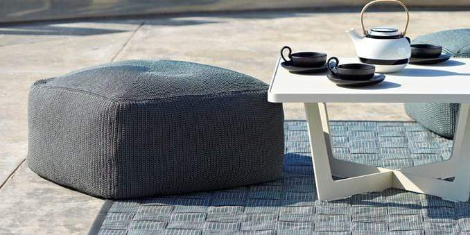Boxhill's Time-Out white outdoor small coffee table with pot and cups on it and dark grey outdoor fabric footstool