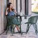 Boxhill's Blend Armchair Outdoor Dark Green lifestyle image with woman sitting down