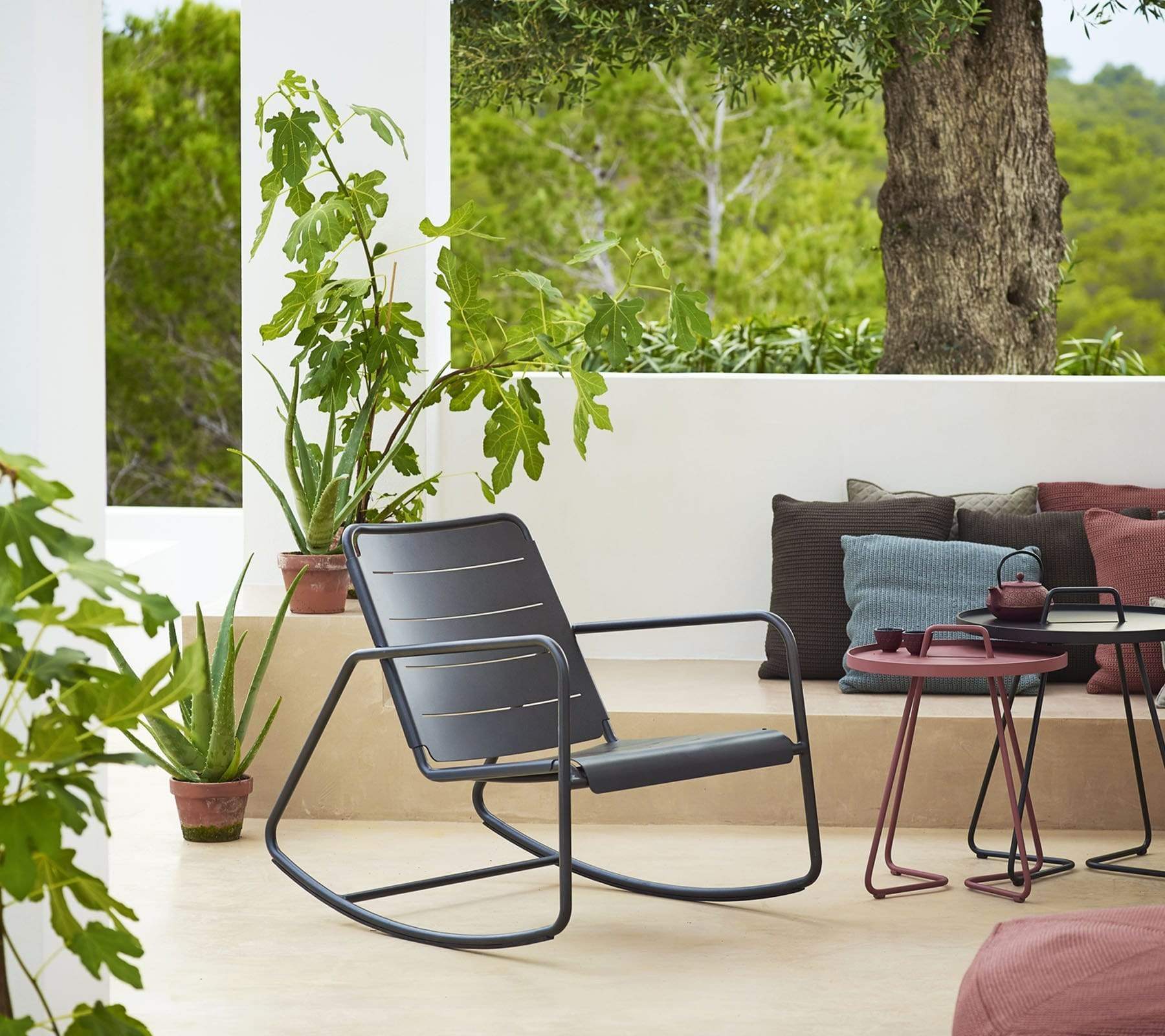 Boxhill's Copenhagen Rocking Chair lifestyle image with side tables and pillows at patio