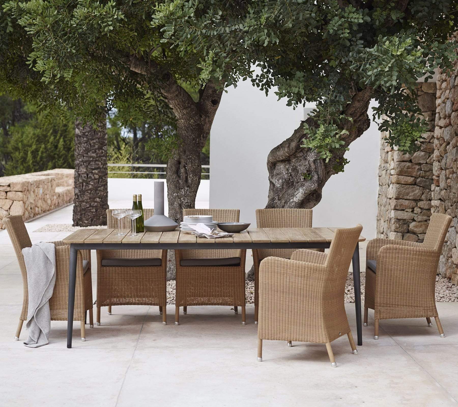 Boxhill's Hampsted Outdoor Dining Armchair lifestyle image with Core Garden Dining Table beside the tree at patio