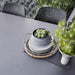 Boxhill's Vibe black outdoor armchair with dark grey outdoor dining table pile of plates and bowl on it