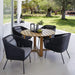 Boxhill's Endless Outdoor Round Dining Table lifestyle image with 4 dining chairs at patio