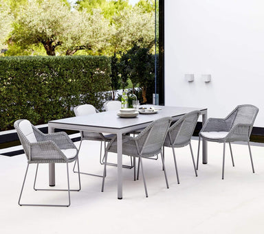 Boxhill's Drop Outdoor Dining Table Light Grey lifestyle image with Breeze Dining Weave Chair at patio